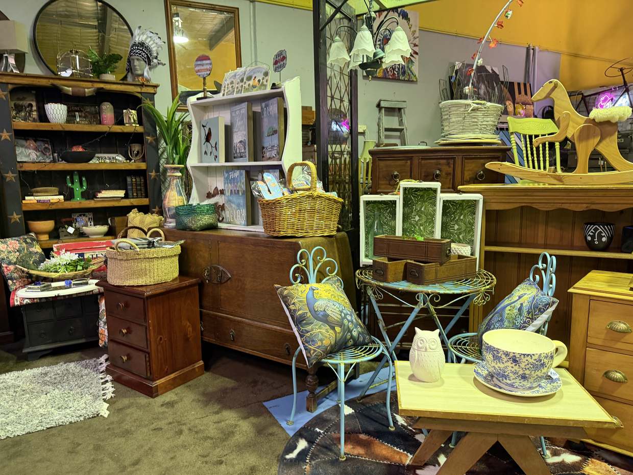Yellow walls, turquoise wire chairs with peacock cushions, a wooden rocking horse and baskets.